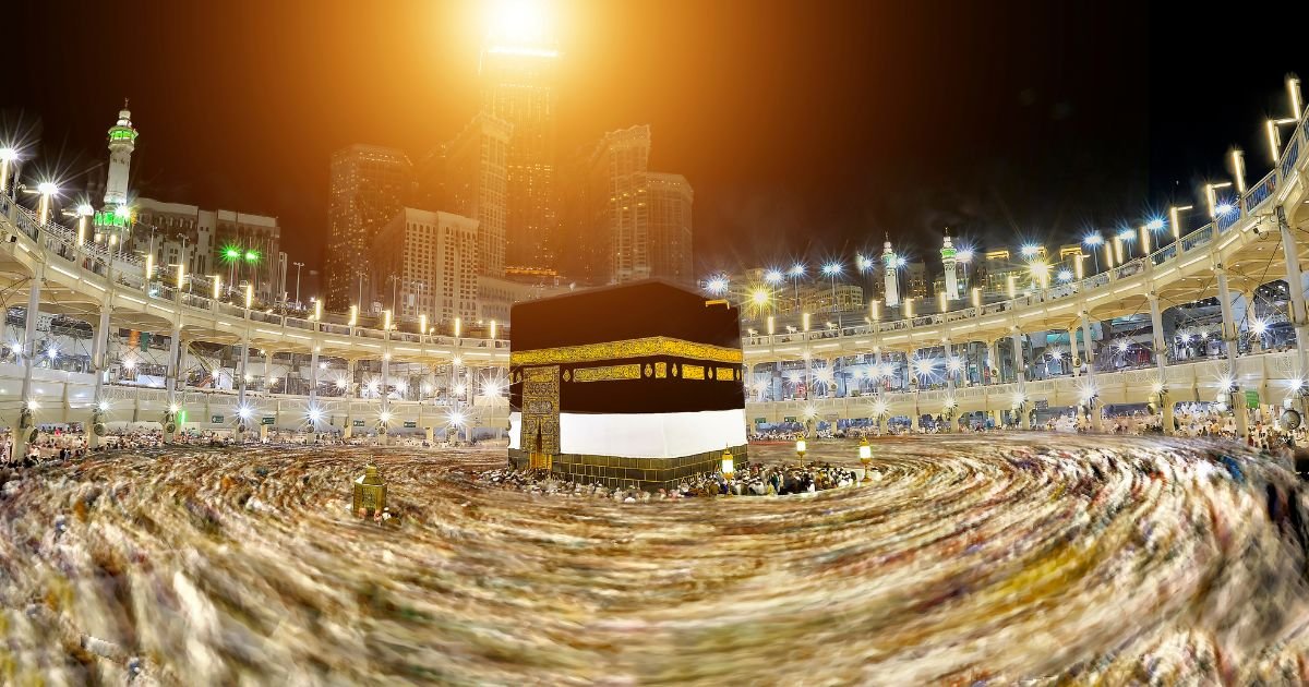 Dynamic long-exposure view of the Kaaba and pilgrims performing Tawaf at night. Umrah packages UK, 5 star Umrah packages UK, and group Umrah UK deals for 2026.